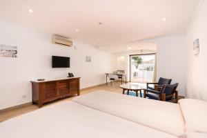 a bedroom with two beds and a table and chairs at Apartamentos Borda D´Agua in Albufeira