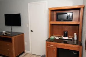 a hotel room with a microwave and a television at Howard Johnson by Wyndham Acton in Acton