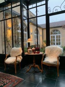 a patio with two chairs and a table with a lamp at Hotel Ter Duinen in Bruges