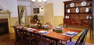 uma sala de jantar com uma mesa de madeira com decorações de Natal em Timbercliffe Cottage Inn em Camden