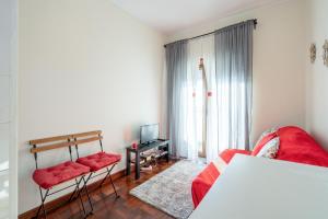 ein Wohnzimmer mit einem roten Sofa und einem TV in der Unterkunft Cozy Apartment Alegria Balcony in Porto