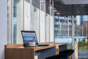 a laptop computer sitting on top of a wooden desk at Holiday Inn Express Edinburgh - Leith Waterfront by IHG in Edinburgh