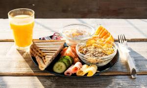 talerz jedzenia z chlebem i tostem oraz szklankę soku pomarańczowego w obiekcie Safestay Athens Monastiraki w Atenach