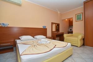 a bedroom with a large bed and a chair at Apartments Mara in Budva