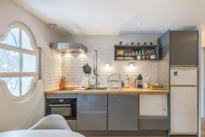 a kitchen with a sink and a refrigerator at Appartement Odyssée - Welkeys in Megève +9 photos