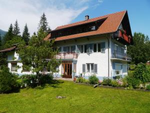 Casa blanca con techo rojo y patio en Haus zur Klamm, en Berg im Drautal