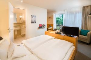 a hotel room with a bed and a television at Baurs Park in Hamburg