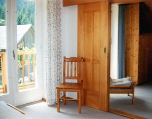 una silla de madera en una habitación con ventana en Haus zur Klamm, en Berg im Drautal