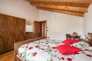una camera da letto con un letto con cuscini rossi di Casa La Guarda a Stenico