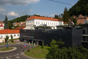 a white building with a red roof in a city at Perfect Apartment Central in Braşov