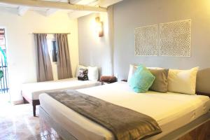 a bedroom with a white bed and white walls at Tropical Rooms Holbox in Holbox Island