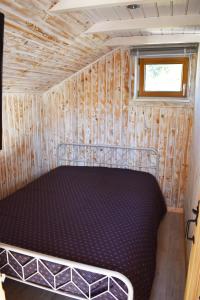 una cama en la parte trasera de una casa pequeña en "La vieille Grange", au coeur de la nature, en Laveline-du-Houx
