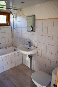 Un baño con lavabo, inodoro y bañera. en "La vieille Grange", au coeur de la nature, en Laveline-du-Houx