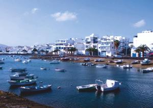 a group of boats in a body of water with buildings at Lantia Rooftop House in Arrecife