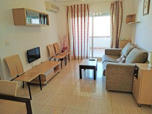 ein Wohnzimmer mit Sofa und Fernseher in der Unterkunft Apartamentos Coral - Marfil Marina Dor 3000 in Oropesa del Mar