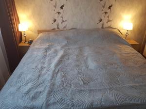 a bed with a white comforter with stars on the wall at Cosy home 10 min from city center in Tallinn