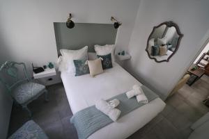 um pequeno quarto com uma cama e um espelho em DreamsApt Placentines em Sevilha