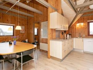 a kitchen with wooden walls and a table in a room at 6 person holiday home in Hvide Sande in Bjerregård