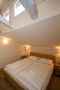 a bedroom with a large white bed with two pillows at Apartments Erica Luxury in Novigrad Istria