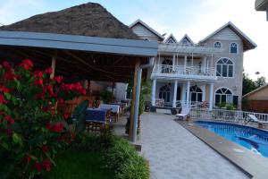 a villa with a swimming pool and a house at Villa Asimba in Kigali
