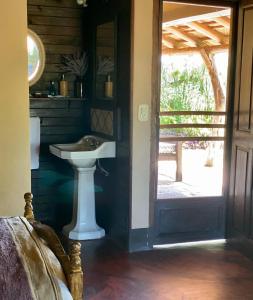 a bathroom with a sink next to a door at Rancho de los Esteros in Colonia Carlos Pellegrini