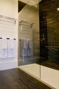 uma casa de banho com uma grande cabina de duche em vidro e toalhas em Chambre D'hôtes sur Île de Nantes em Nantes