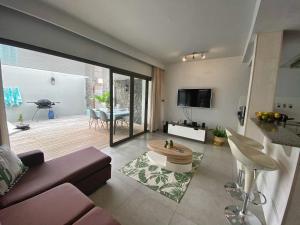 a living room with a couch and a table at Under The Tropics in Tamarin