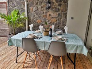 een tafel met stoelen en een blauwe tafeldoek erop bij Under The Tropics in Tamarin