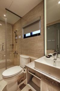 台南的住宿－文悅旅棧，浴室配有卫生间、盥洗盆和淋浴。
