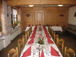 einen langen Tisch mit roten Servietten und Weingläsern in der Unterkunft Ferienwohnungen Landgasthof Gilsbach in Winterberg