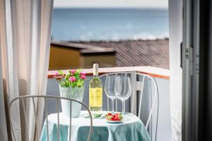 einen Tisch mit einer Flasche Wein und zwei Gläsern in der Unterkunft Aroma di Naxos Apartment in Giardini-Naxos
