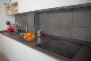 a kitchen with a bowl of oranges on a counter at Lovely Modern Flat Valencia center in Valencia