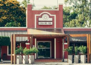 a red building with a clock on top of it at Casa del Sol Hotel & Restaurante in Colonia del Sacramento