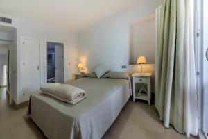 a bedroom with a bed and two tables and two lamps at Villas Flamenco Beach Conil in Conil de la Frontera