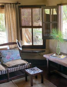 a living room with a couch and a table and a window at Rancho de los Esteros in Colonia Carlos Pellegrini