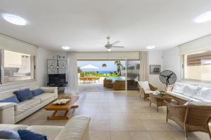 een woonkamer met banken en stoelen en een tafel bij Protaras Beachfront Villa Pietra in Protaras