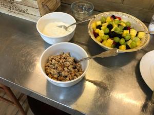 due ciotole di cereali e una ciotola di frutta su un bancone di The Squibb Houses a Cambria