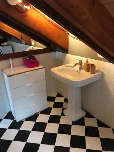 ein Badezimmer mit einem Waschbecken und einem schwarz-weiß karierten Boden in der Unterkunft Villa Emilia in Craveggia