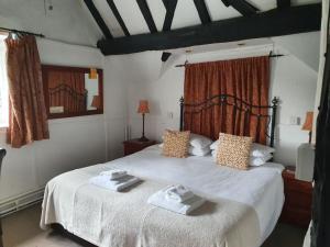a bedroom with a large bed with towels on it at Old Court Hotel & Apartments in Symonds Yat