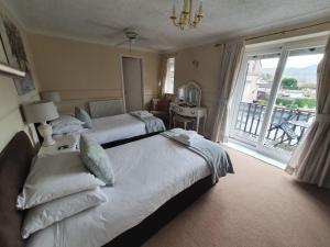a hotel room with two beds and a large window at Old Court Hotel & Apartments in Symonds Yat
