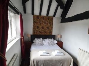 a bedroom with a bed with towels on it at Old Court Hotel & Apartments in Symonds Yat