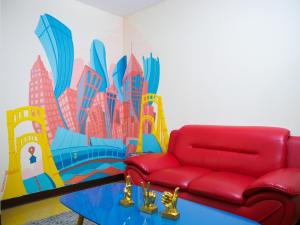 a living room with a red couch and a mural at Stay Pittsburgh in Pittsburgh