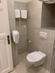 a bathroom with a toilet and a shower with towels at W19 Apartments in Miskolc
