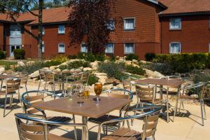 eine Terrasse mit Tischen und Stühlen vor einem Gebäude in der Unterkunft Holiday Inn Express Portsmouth – North, an IHG Hotel in Portsmouth