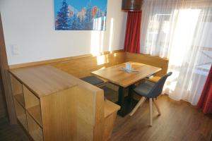 シュラートミンクにあるHaus Mozartの木製テーブルと椅子が備わる小さな客室です。