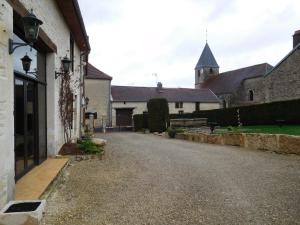 an empty road leading to a building with a church at la forge in Lanty-sur-Aube
