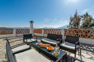 a patio with chairs and tables on a balcony at Dreams Alpujarra in Pampaneira
