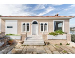 a house with a white door and stairs in front at Artemis Villa near Athens airport in Markopoulo