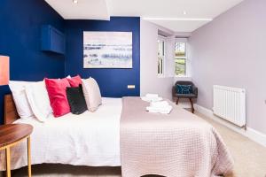 1 dormitorio con 1 cama blanca grande con almohadas rojas en Newcastle Treasure - sleeps 4, en Newcastle