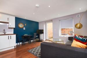 a kitchen and a living room with a couch and a table at Newcastle Treasure - sleeps 4 in Newcastle upon Tyne